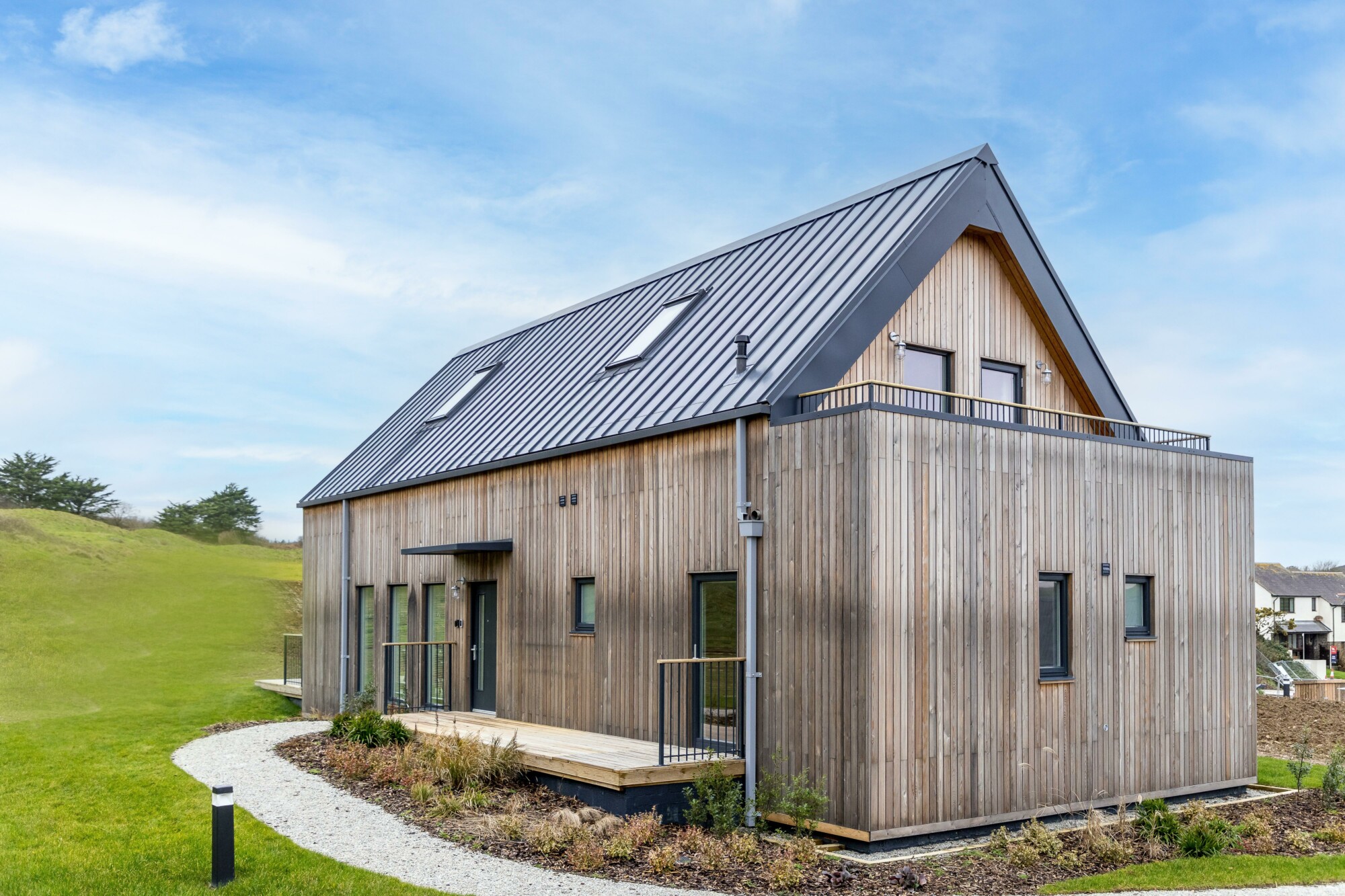 Timber-clad holiday home and gravel paths at Willingcott Valley.