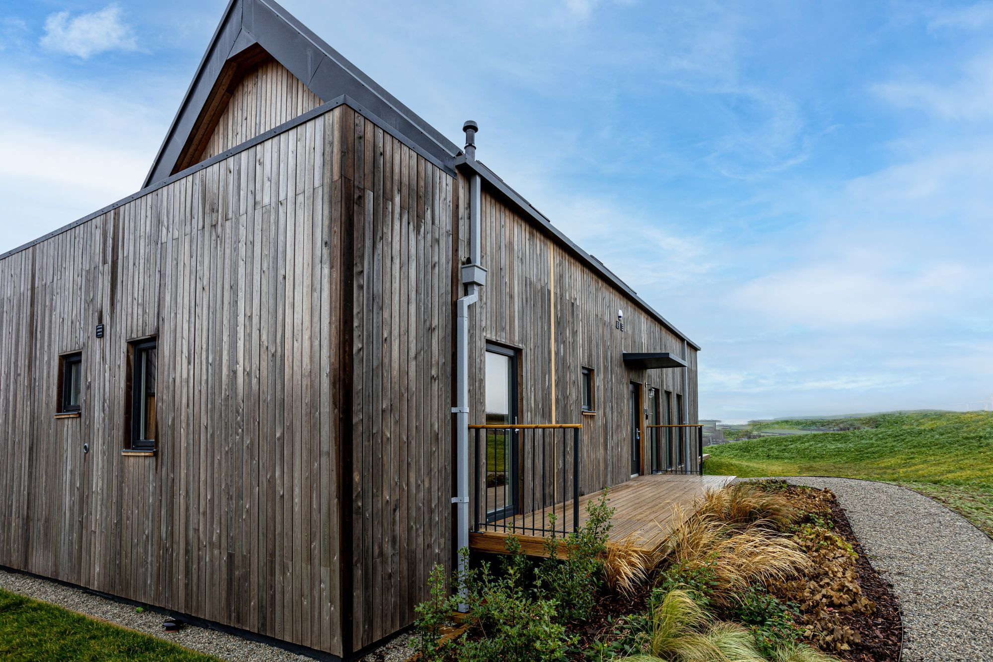 Timber building, gravel route and planted borders at Willingcott Valley.